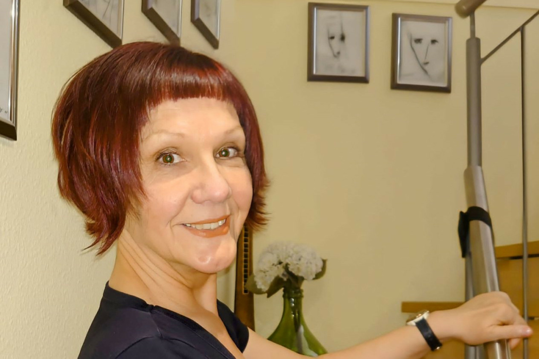 Porträt einer Frau, die lächelnd in die Kamera schait.