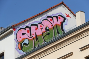 Graffiti-Schriftzug an Hausgiebel.