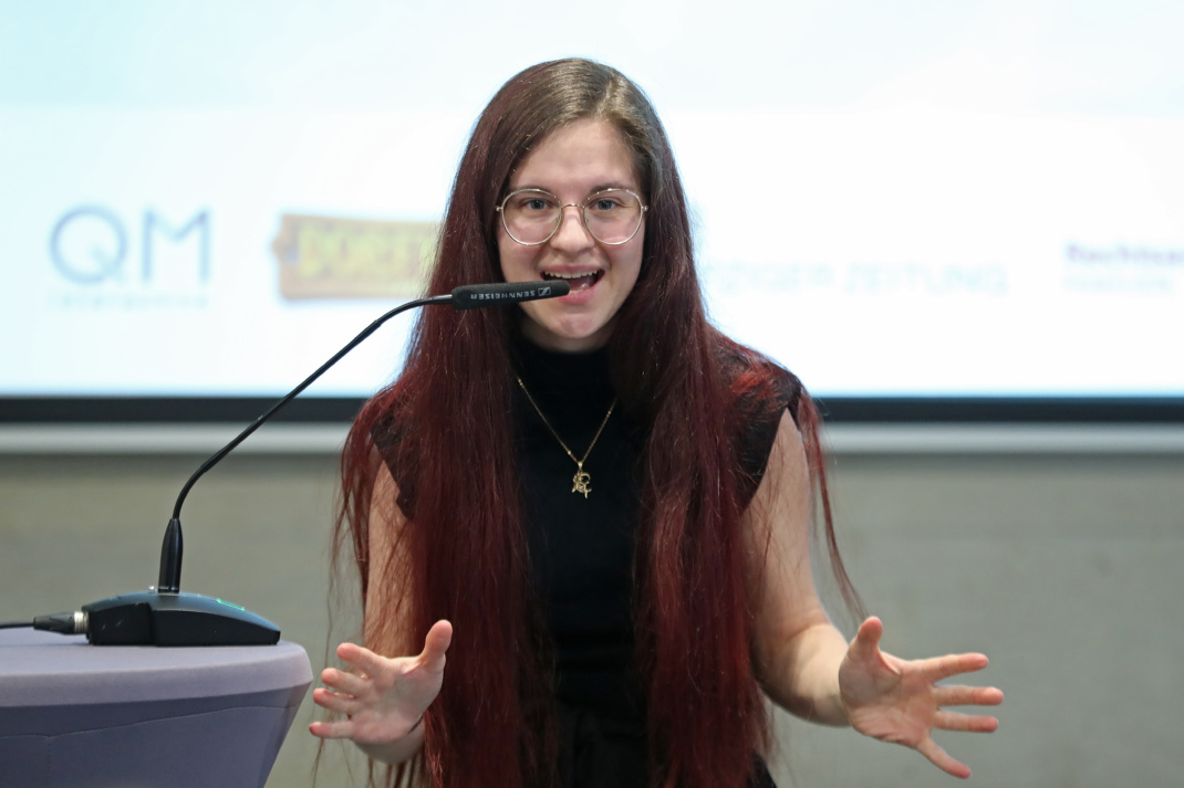 Junge Frau vor einem Rednerpult.