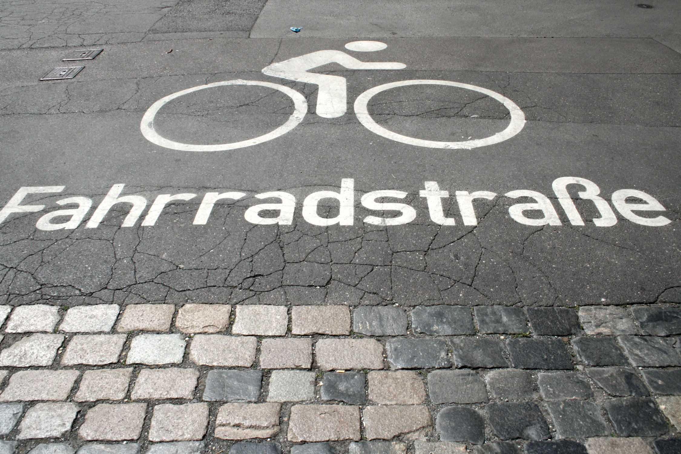 Fahrbahnmarkierung für eine Fahrradstraße, weiß auf grau.