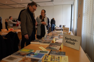 Mehrere Personen an einem Büchertisch.