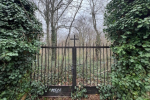 Zugang zu einem alten Friedhof, Tor mit Kreuz.