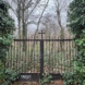 Zugang zu einem alten Friedhof, Tor mit Kreuz.