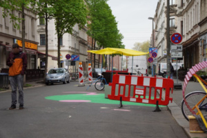 Blick in einen Straßenbereich, der zum Teil bunt bemalt und abgesperrt ist.