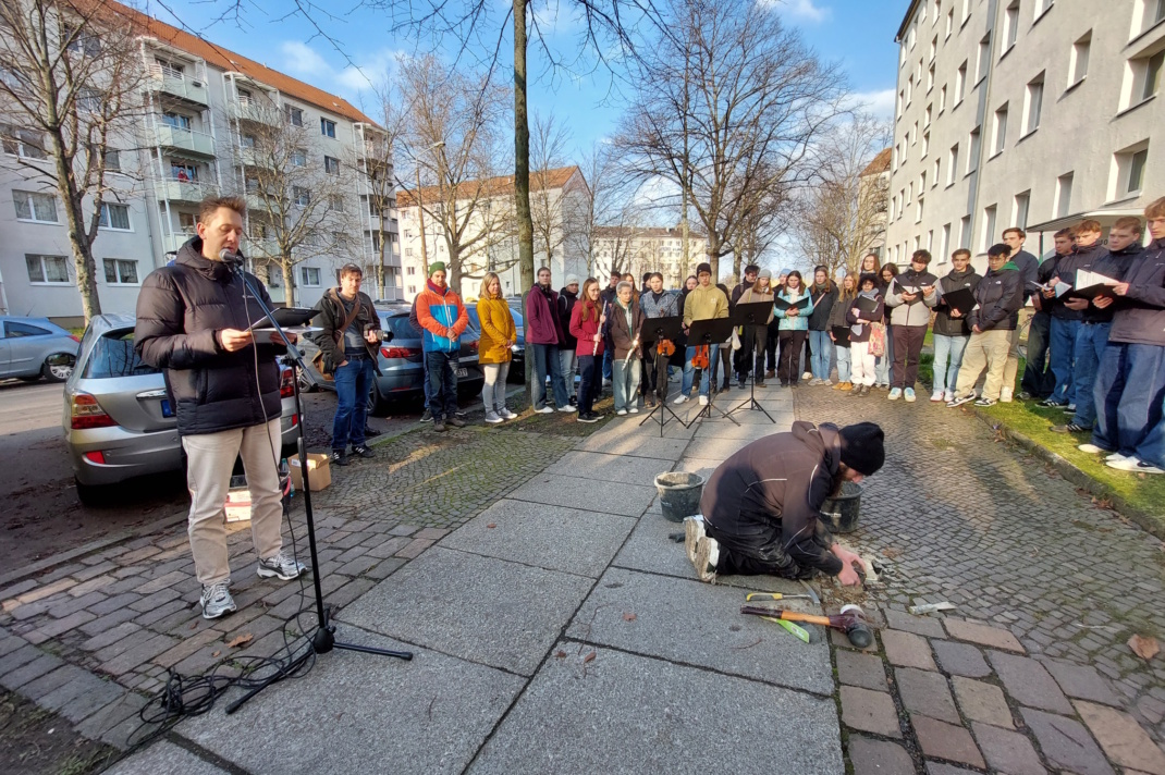 Stolpersteinverlegung, Menschenmenge auf dem Gehsteig.