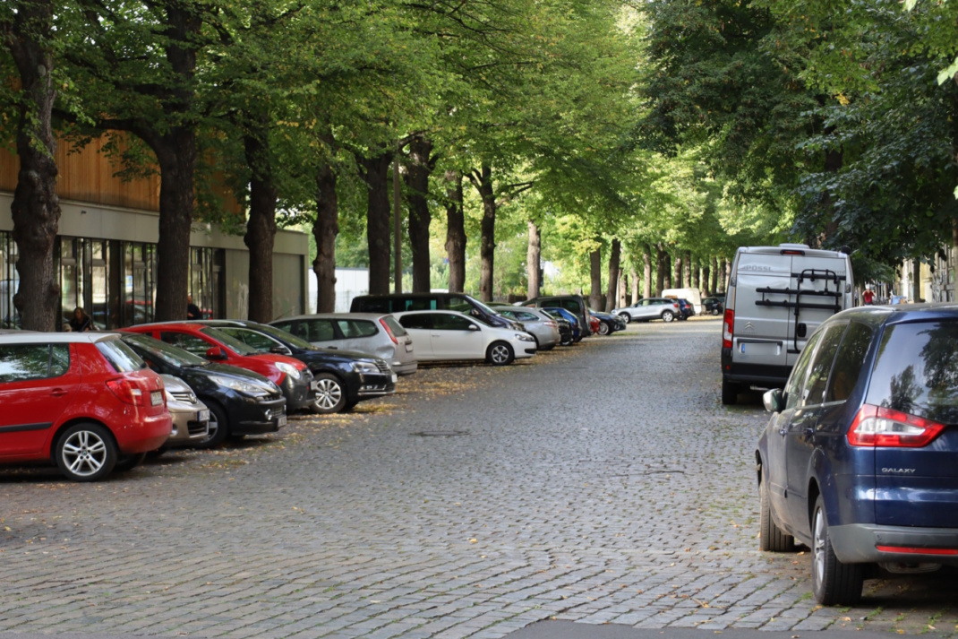 Straße im Wohngebiet mit abgestellten Fahrzeugen