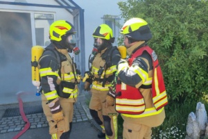 Drei Feuerwehrmänner mit Gasmasken