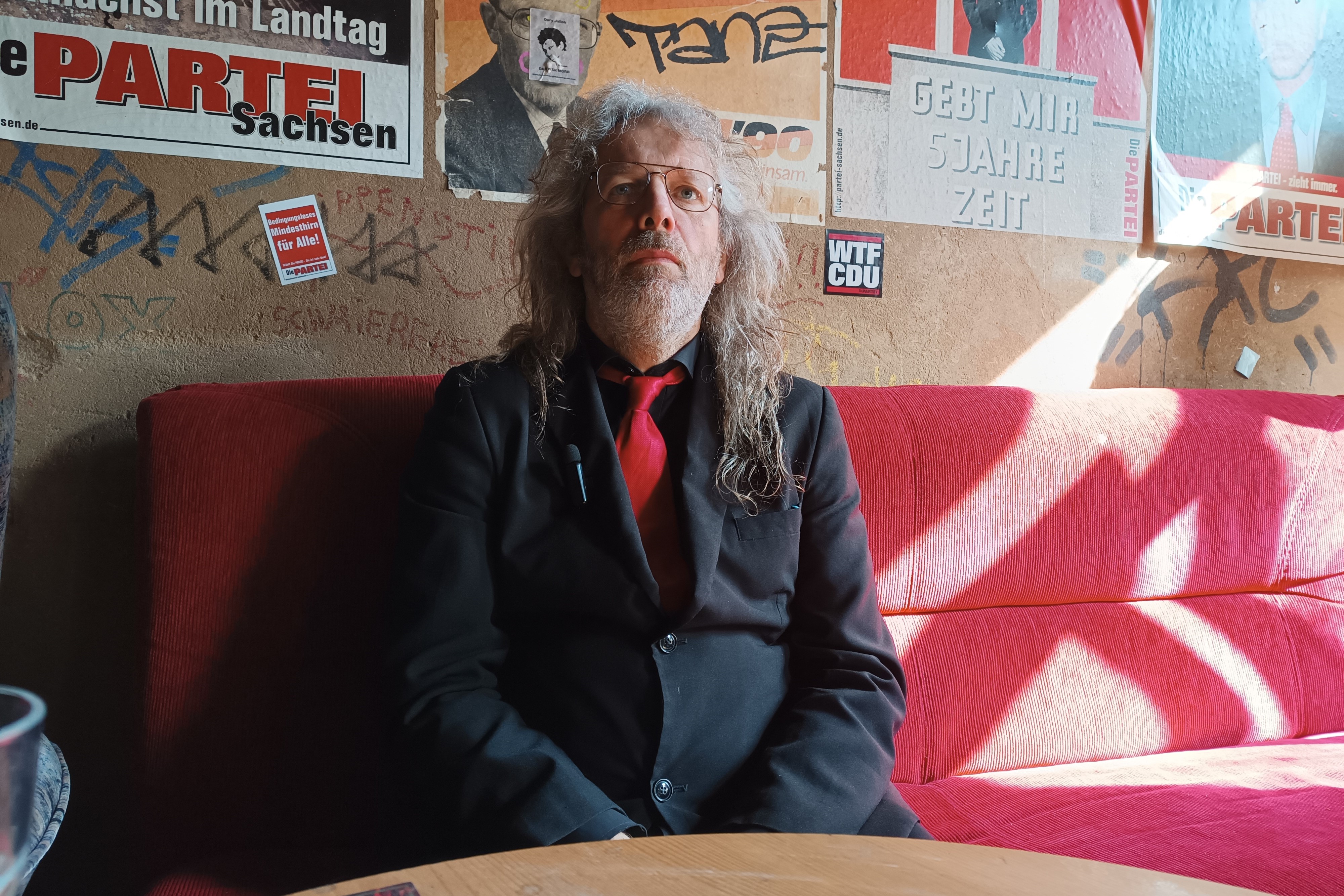 Thomas Kumbernuss (Die PARTEI), sitzend in einem Zimmer.