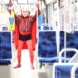 Mann in roter Verkleidung in Straßenbahn.