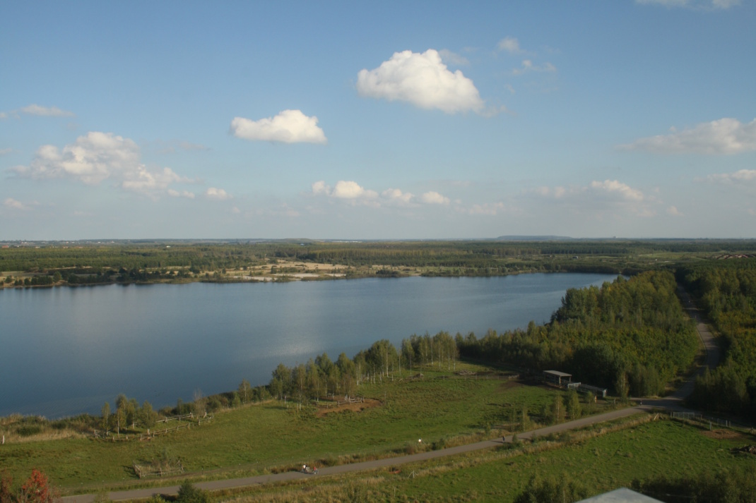 Blick auf einen See, blauer Himmel und Wolken.