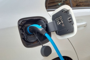 Offener Tankdeckel eines Elektroautos, das beladen wird.
