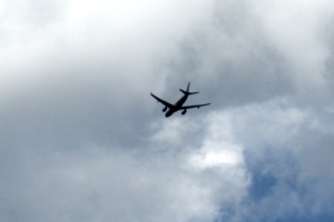 Flugzeug am Himmel, Wolken, vom Boden aus aufgenommen.