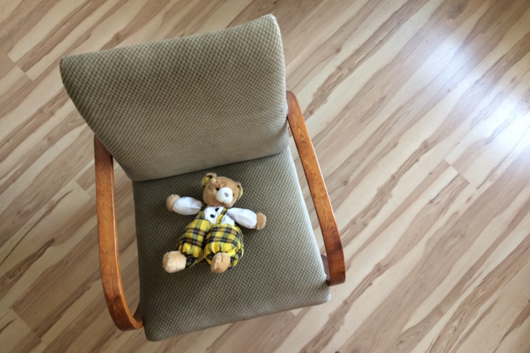 Teddy auf Stuhl liegend, Aufnahme von oben.