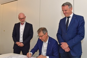 Landrat Kai Emanuel unterzeichnet im Beisein von WGD-Geschäftsführer André Planer (l.) und Oberbürgermeister Manfred Wilde (r.) den Mietvertrag. Foto: LRA/Bley