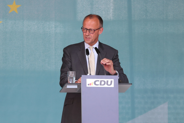 Friedrich Merz spricht an einem Rednerpult mit CDU-Logo.