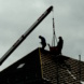 Arbeiter auf einem Hausdach.