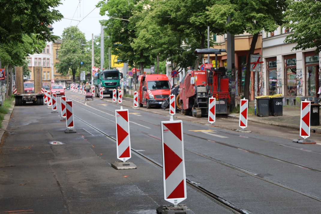 Baustelle mit Baken und Fahrzeugen auf der Straße.