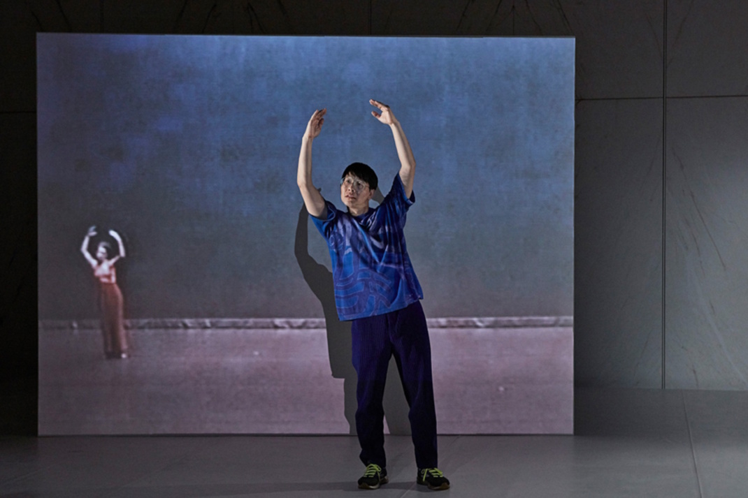 Person auf der Bühne streckt ihre Arme nach oben.