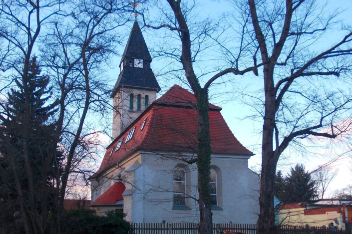 Rückansicht einer Kirche, von Bäumen umgeben.
