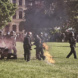 Polizeibeamte auf Wiese, Uniform hat nach Angriff Feuer gefangen.