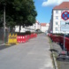 Seitenstraße im Wohngebiet, Bäume und Baustellenmarkierungen.