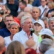 Mann spricht in einer großen Menschenmenge ins Mikro.