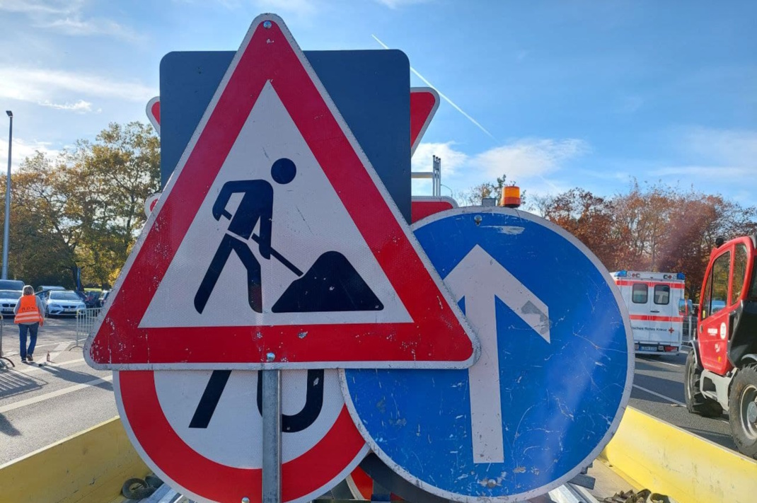 Verkehrsschilder an einer Straße stehen dicht hintereinander.