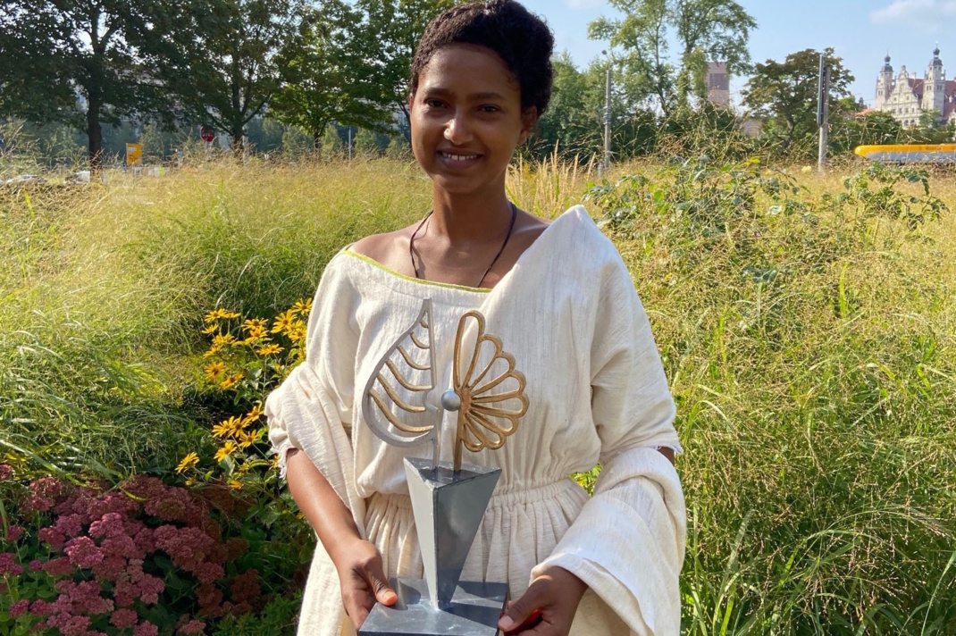 Frau steht in Landschaft.