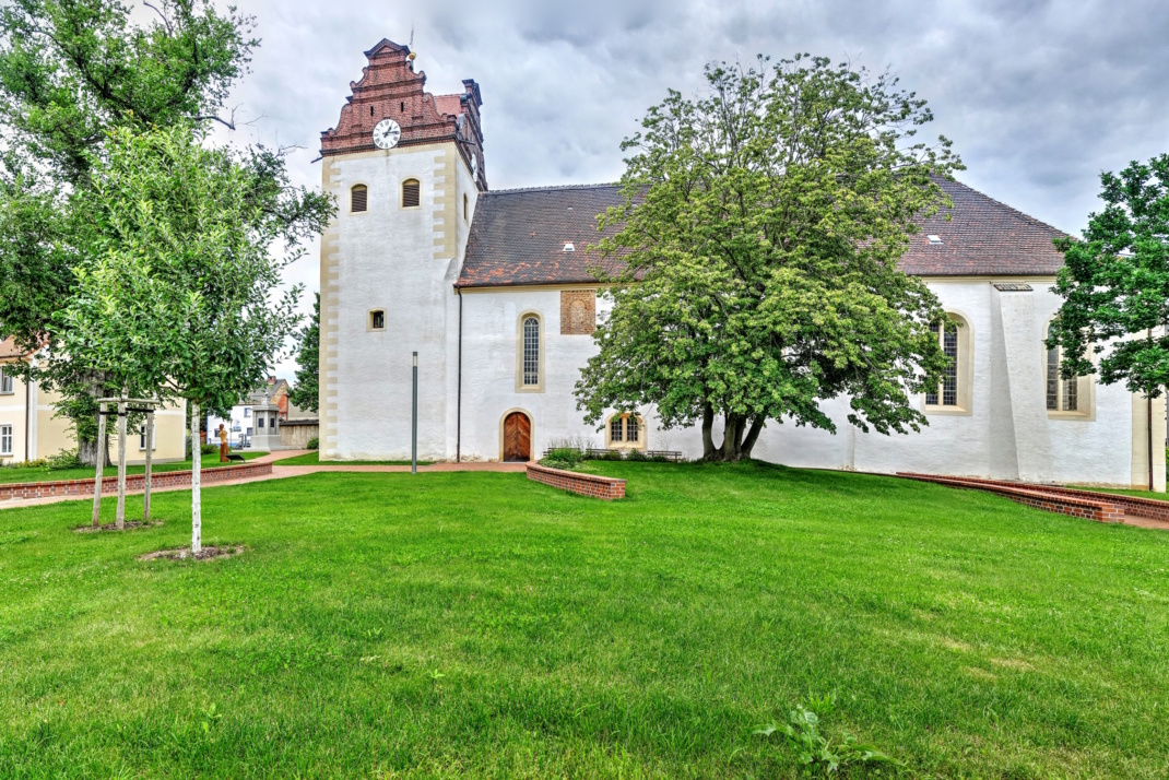 Kirche auf grünem Hügel.