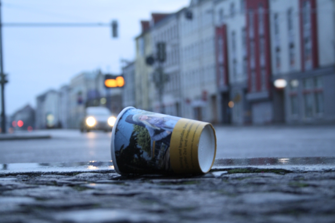 Pappbecher auf dem Gehsteig, Nahaufnahme.