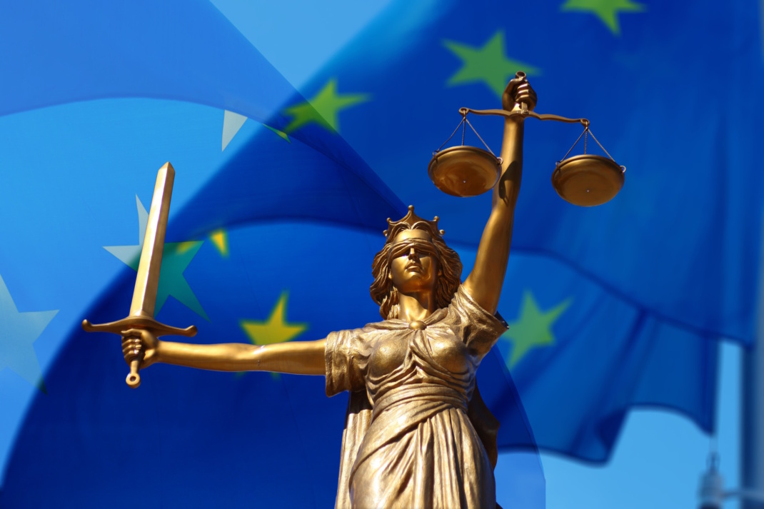 Symbolische Justitia vor blauer Europaflagge.