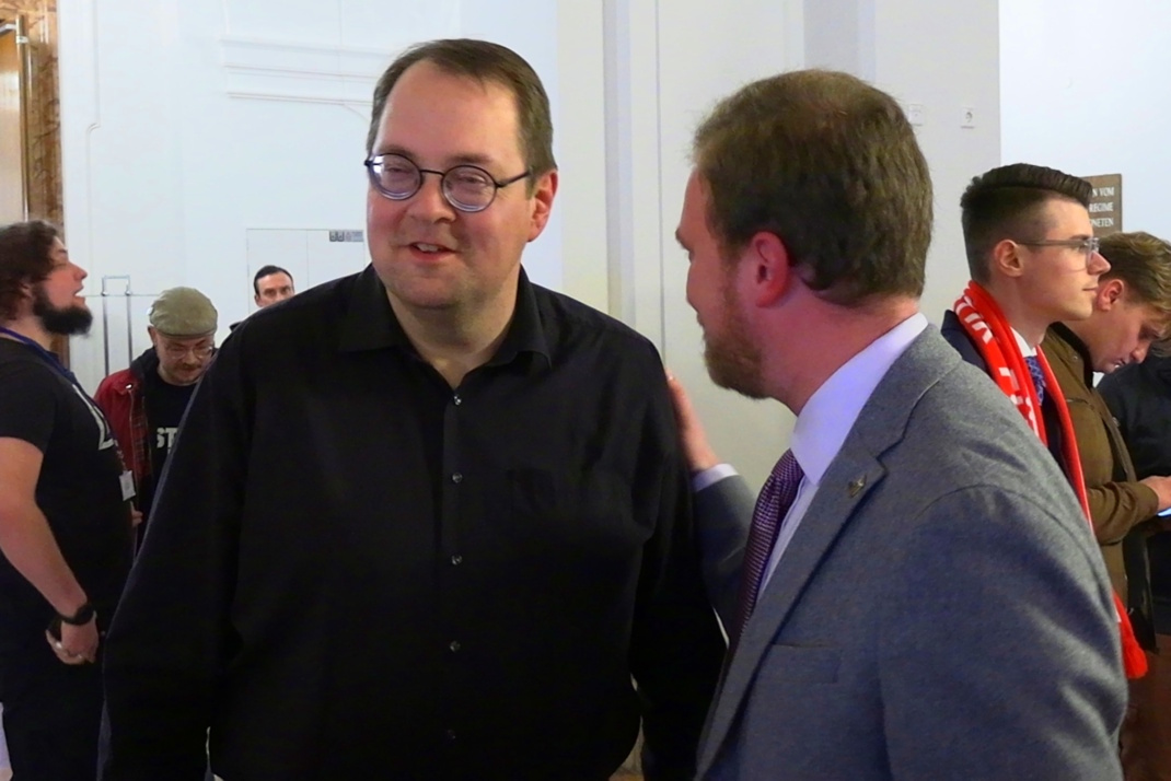 Zwei männliche Personen stehen nebeneinander.