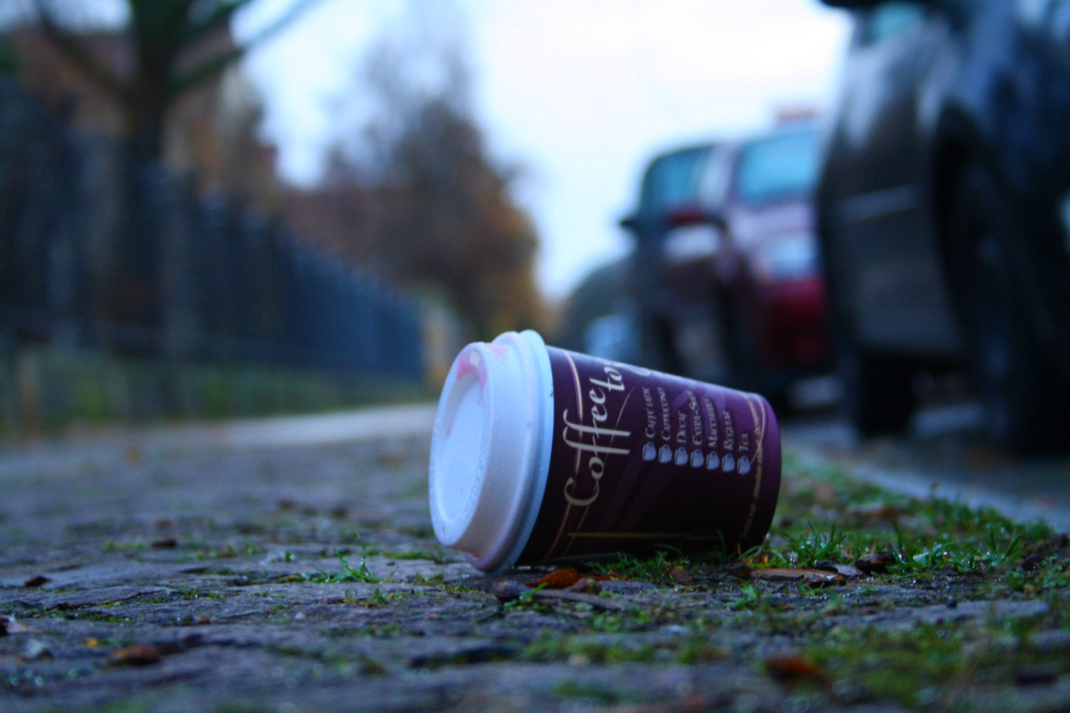 Einweg-Becher im Straßenbild, Nahaufnahme aus Bodenperspektive.