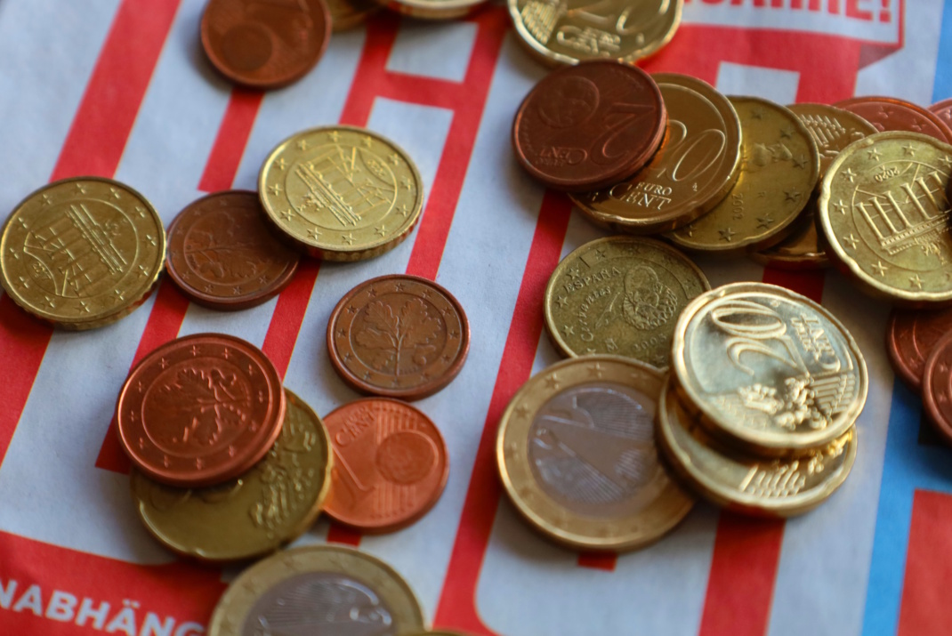 Euro-Geldstücke auf gestreiftem Untergrund.