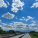 Autobahn, blauer Himmel und Wolken.