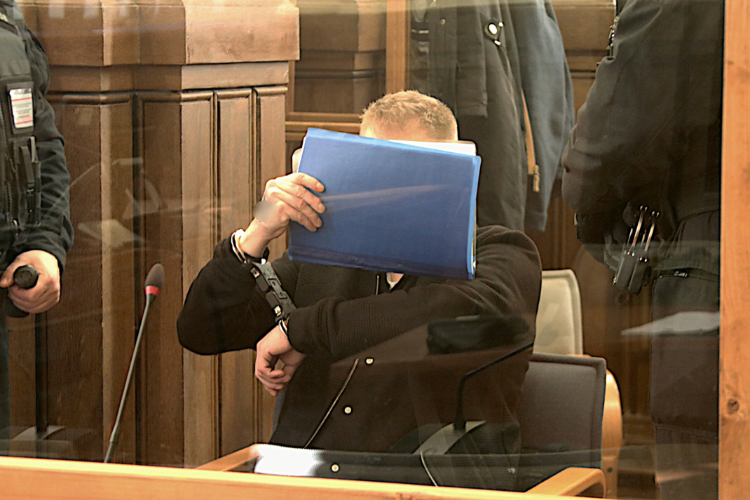 Angeklagter mit blauer Mappe im Landgericht.