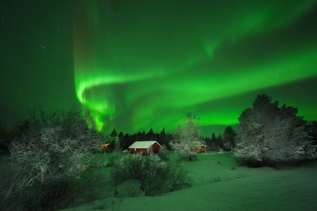 Grüne Polarlichter in einer Landschaft.