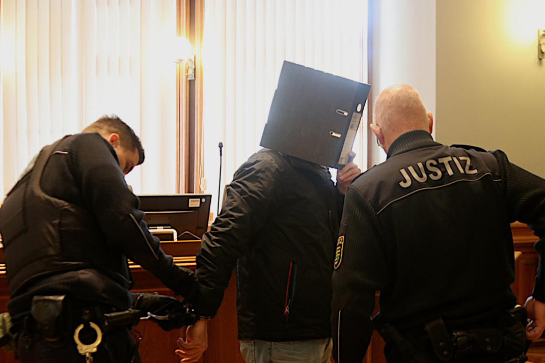 Angeklagtem werden Handfesseln abgenommen.