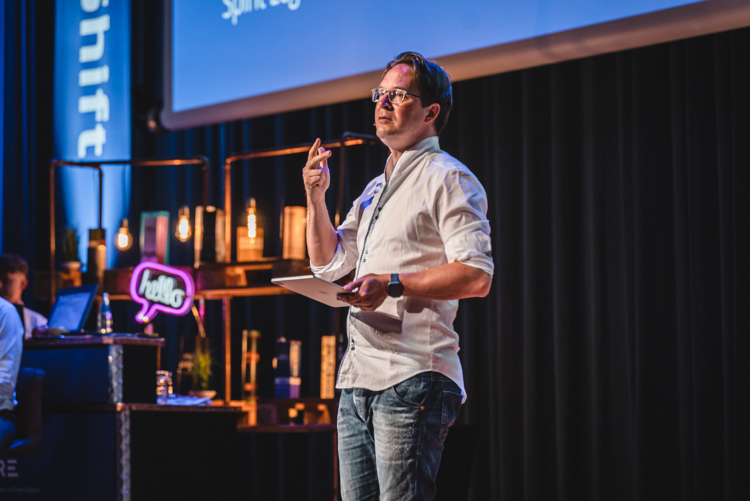 Mann bei Vortrag auf einer Bühne.