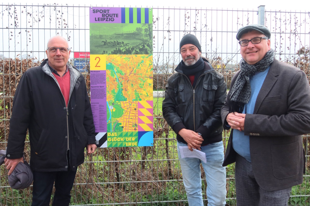 Personengruppe steht an Verkündungstafel nebeneinander,