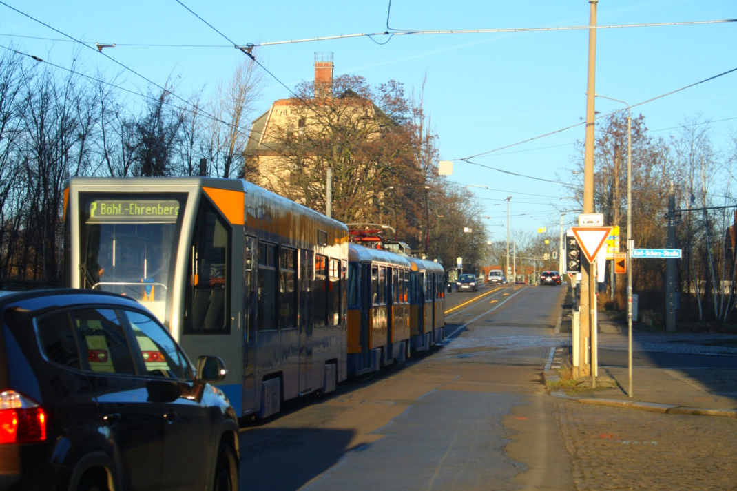 Brückenauffahrt mit Tram und Autos.