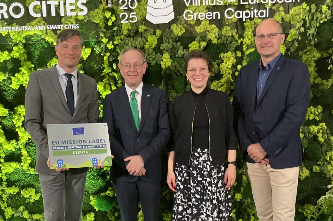 Personengruppe steht nebeneinander, Person links hält ein Dokument,