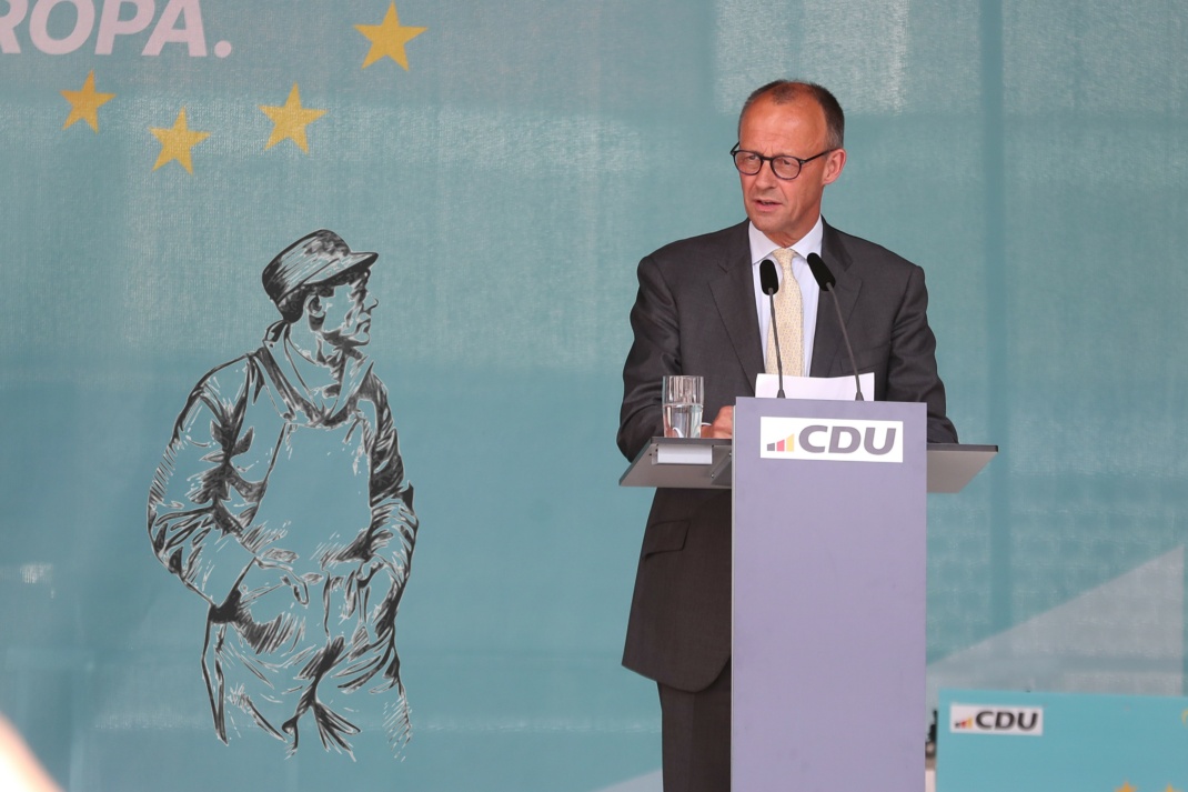 Arbeiter schaut kritisch auf Friedrich Merz, während dieser von Arbeit redet