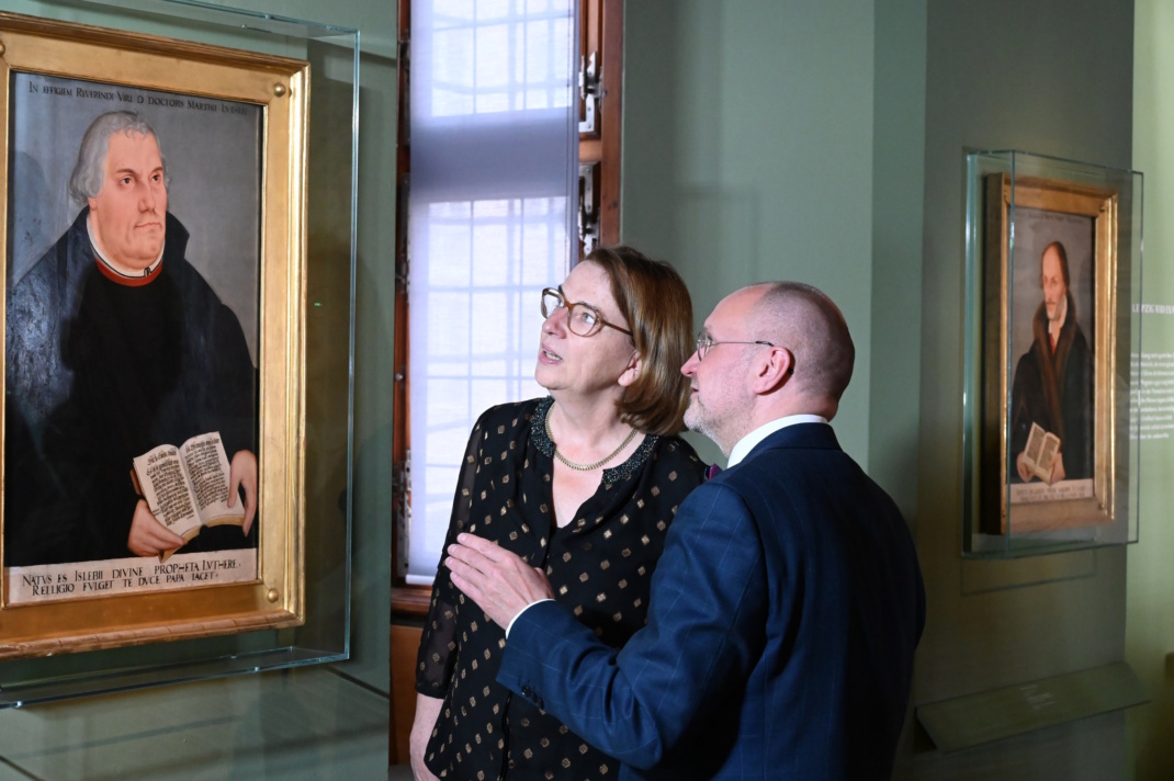 Zwei Personen blicken auf ein Luther-Gemälde.