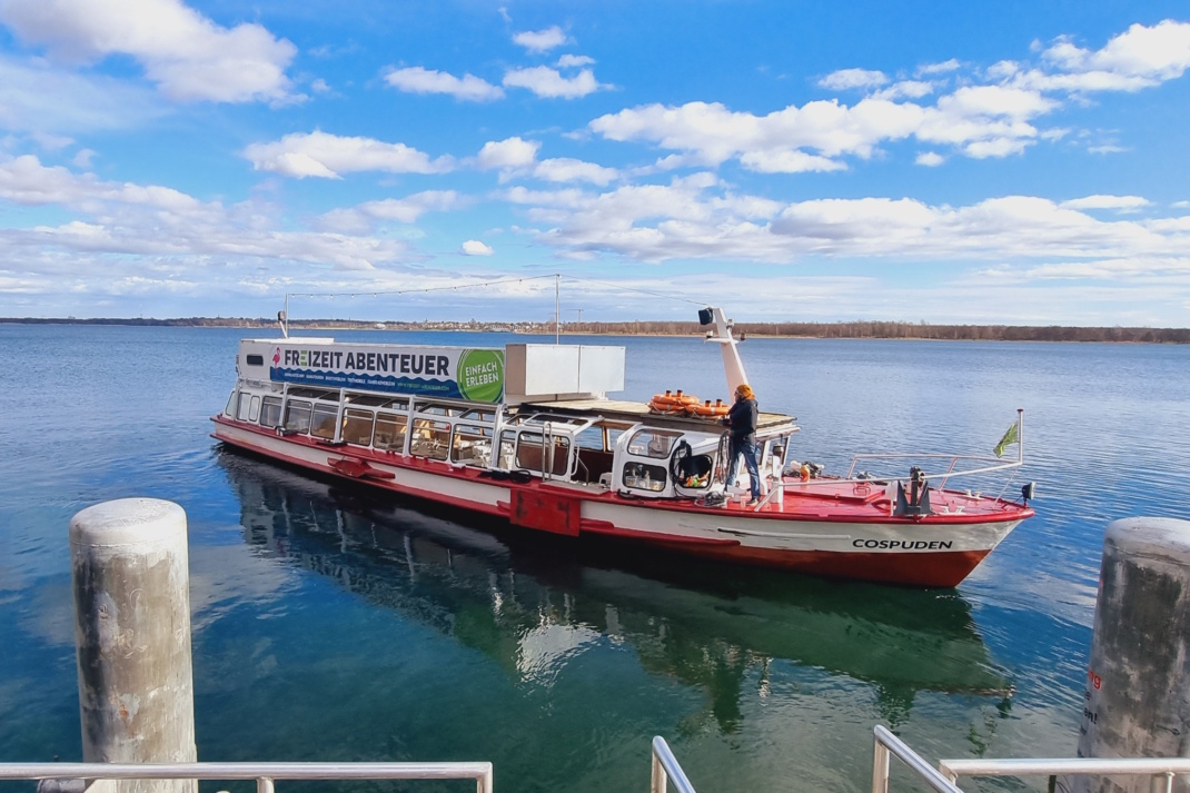 Boot nahe des Stegs auf einem See, Himmel und Wolken.
