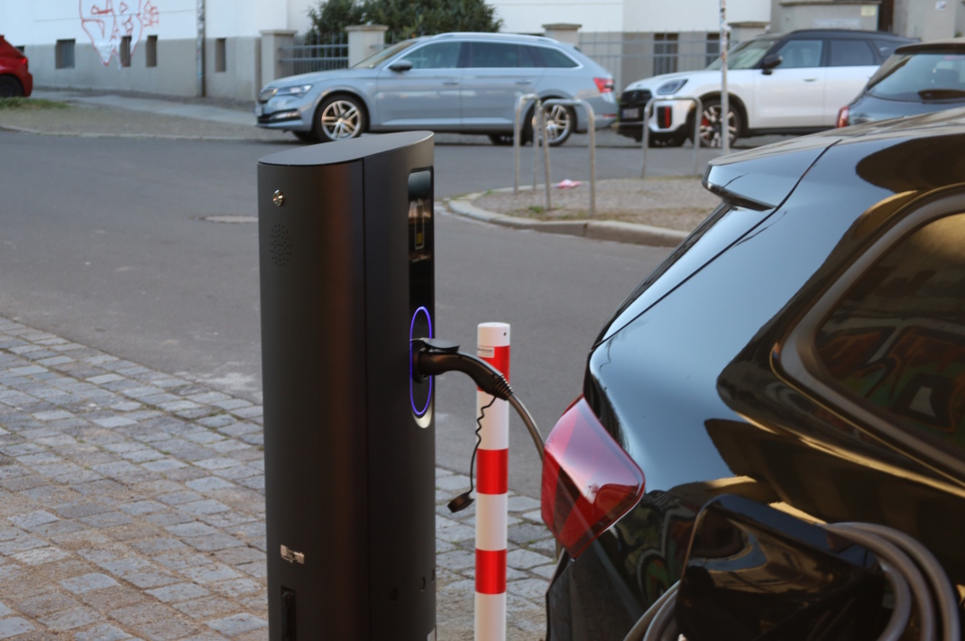 Heck eines Autos, das ein einer E-Ladesäule aufgeladen wird.