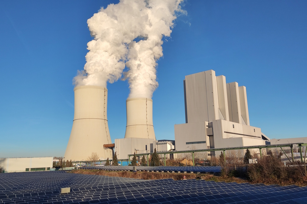 Kohlekraftwerk, rauchende Schlote vor blauem Hmmel.