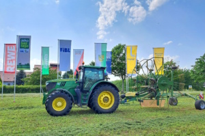 Traktor auf Wiese, Fahnen im Hintergrund.