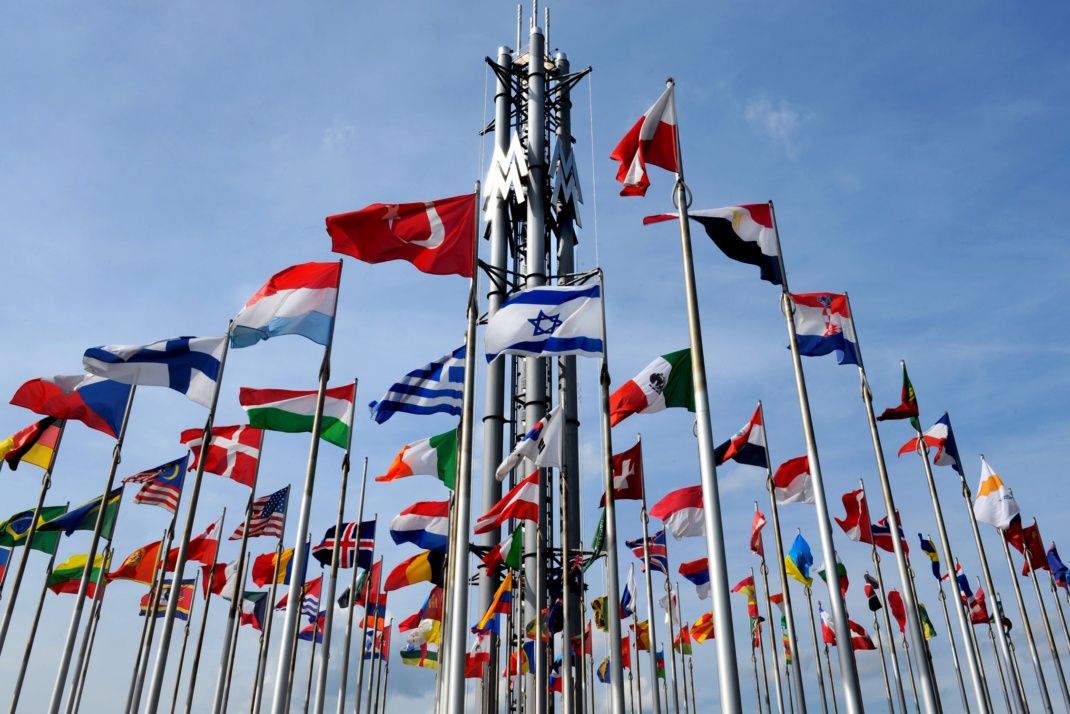 Flaggenwald am Leipziger Messegelände, blauer Himmel.
