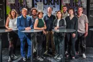 Menschengruppe, die sich an zwei Tischen aufgestellt hat.